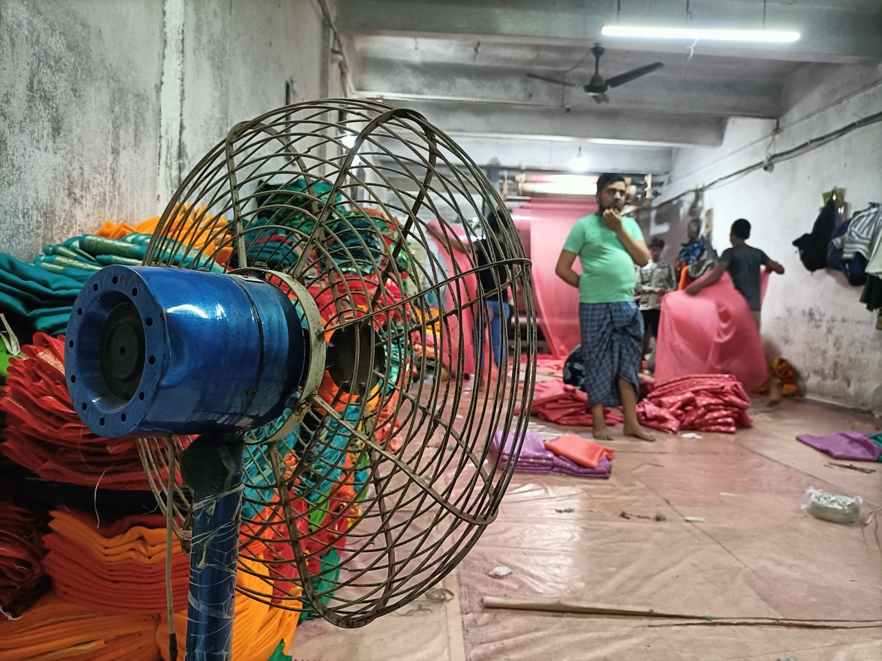 Inside a printing and dyeing unit. The visible lack of ventilation or natural light is a common feature across informal workspaces in Surat.